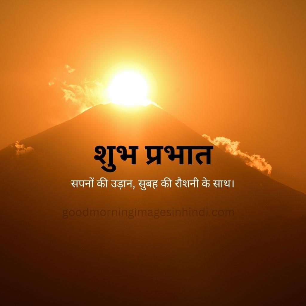 Shubh Prabhat! A yellow sun, like a blazing eye, peeks through a break in stormy clouds, casting a dramatic light on the mountain peaks good morning images in hindi