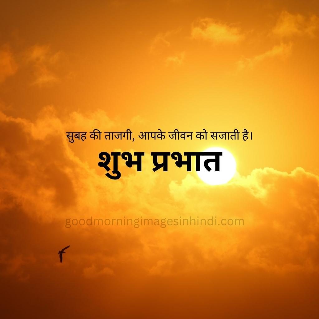 Shubh Prabhat! A fiery yellow sun casts a warm glow on the rugged slopes of a wispy clouds drifting overhead good morning images in hindi