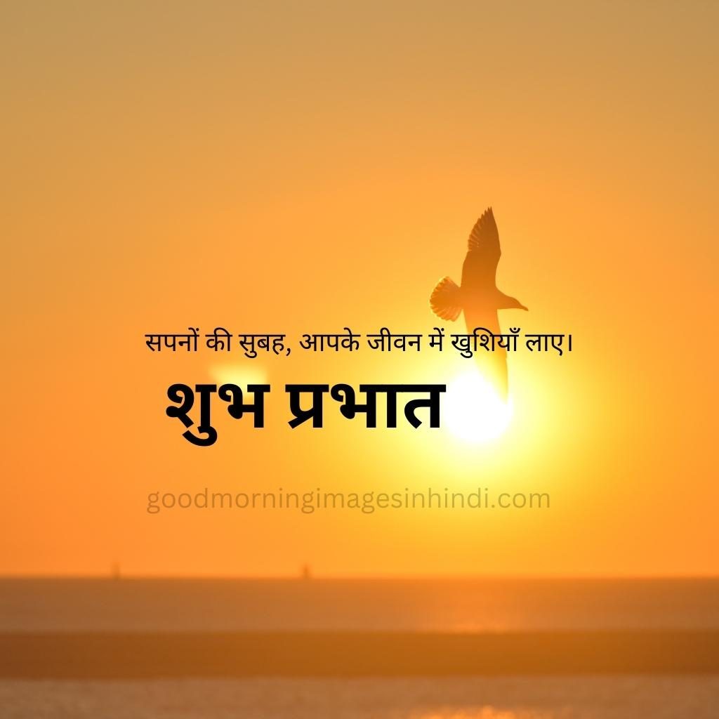 Shubh Prabhat! A single yellow sun peeks through a vibrant orange sky filled with wispy clouds, a bird flying good morning images in hindi